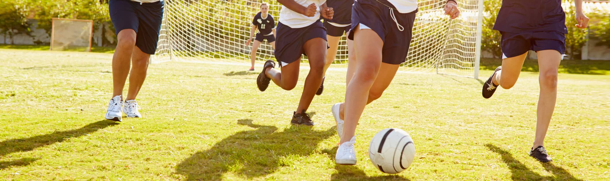 Members of female high school soccer playing match